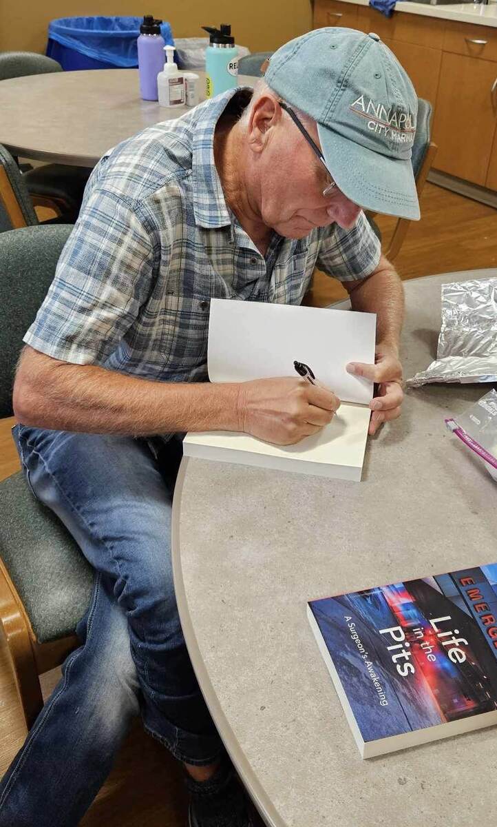 Nicholas Maxwell signing a copy of Life in the Pits